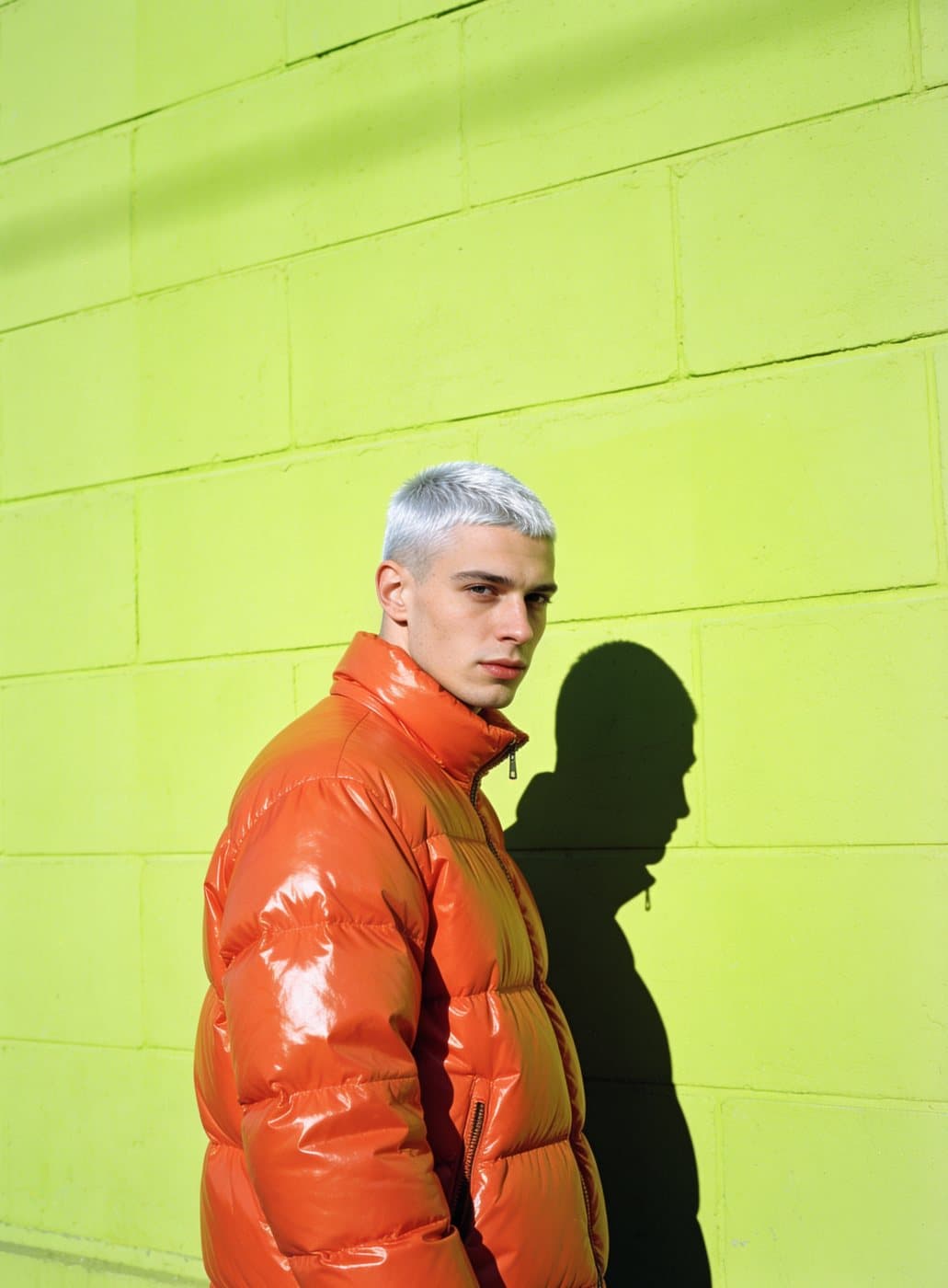 Portrait of a silver-haired man in a tangerine puffer jacket